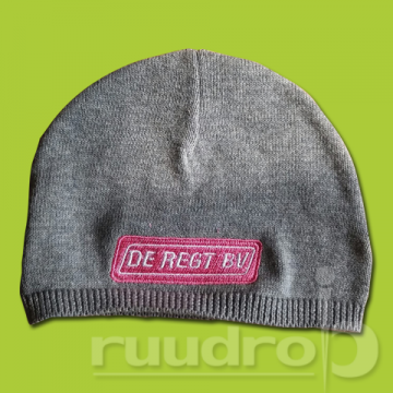 gebreid licht grijze baby muts met een roze geborduurd de regt logo