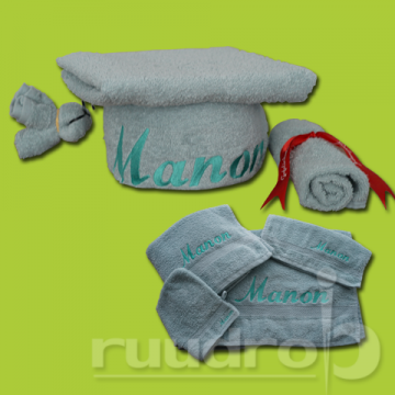 Cadeaupakket van handdoeken geborduurd met naam manon ingepakt als academische pet