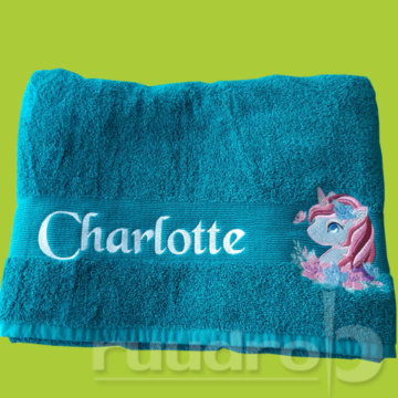 Een smaragdgroene handdoek met hierop de naam Charlotte en een figuurtje uit onze collectie erop geborduurd.