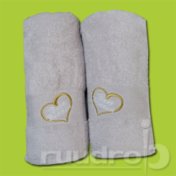 Twee geborduurde licht grijze handdoeken met een hartje en twee namen erin