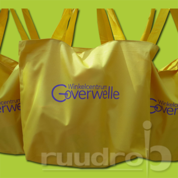 Gele strandtassen met het logo van Goverwelle erop bedrukt in paarse transferfolie