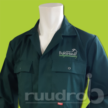 Een groene overall geborduurd met het borstlogo van Buikshoeve melkgeitenhouderij
