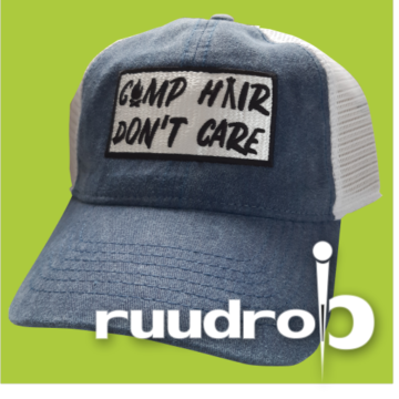 Vaal blauwe truckers pet met een geborduurd logo van camp hair don't care